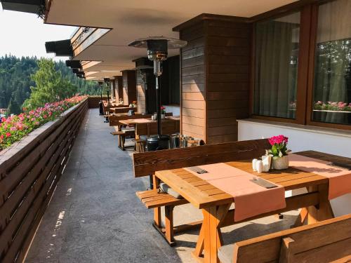 a row of wooden tables and benches on a restaurant at Teleferic Grand Hotel in Poiana Brasov