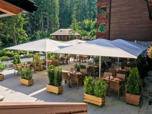 a restaurant with tables and umbrellas on a patio at Teleferic Grand Hotel in Poiana Brasov