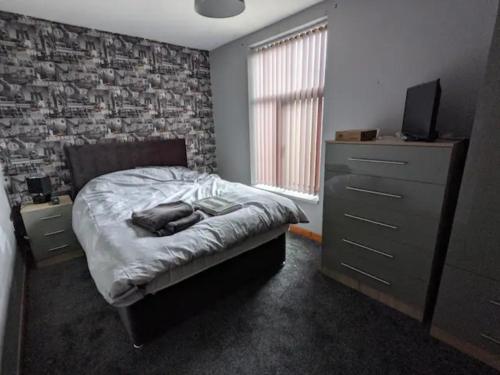 a bedroom with a bed and a brick wall at Cheap and Cosy Rooms with TV in Clayton le Moors