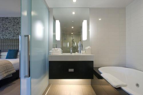 
a bathroom with a white bath tub and a white sink at The George in Christchurch
