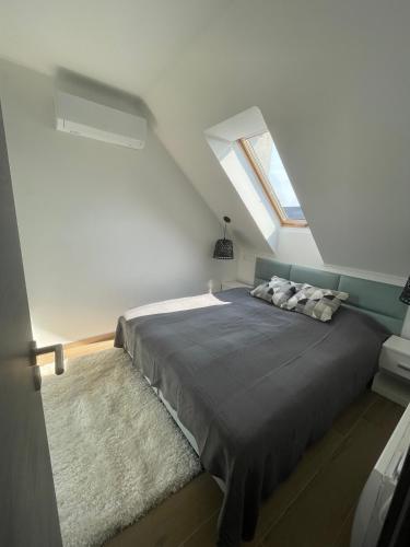 a bedroom with a large bed in a attic at Hello 3B Apartman in Keszthely