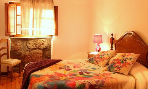 una camera da letto con un letto, una lampada e una finestra di Casa do Palheiro a Campo do Gerês
