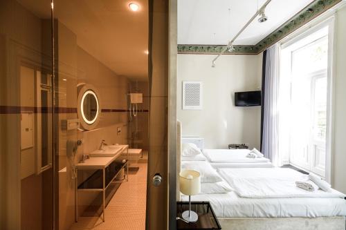 een kamer met 3 bedden, 2 wastafels en een raam bij Home Aparthotel in Krakau