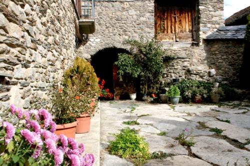 a stone building with plants and flowers in a courtyard at Ramonet in Son