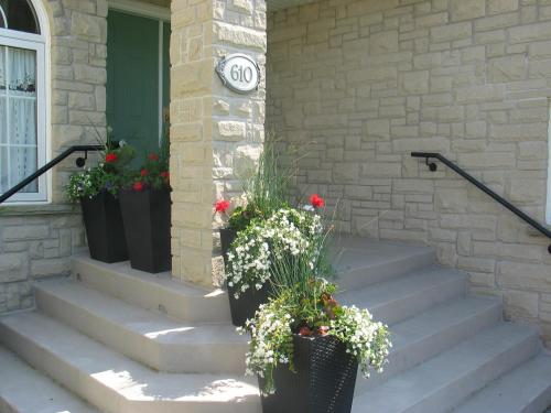 a porch with stairs with flowers in front of a building at Arnica Bed & Breakfast in Niagara on the Lake