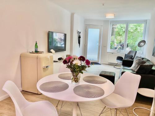 - un salon avec une table et des chaises blanches dans l'établissement 3-Raum Apartment Quartier57 Hamburg-Eppendorf, à Hambourg