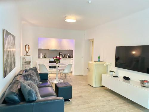 - un salon avec un canapé et une grande télévision dans l'établissement 3-Raum Apartment Quartier57 Hamburg-Eppendorf, à Hambourg