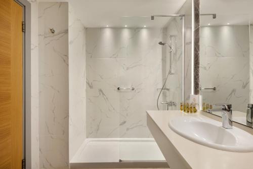 a white bathroom with a sink and a shower at La Quinta by Wyndham Bodrum in Bodrum City