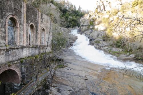 an old stone building next to a river at Altamira in Caldas de Reis