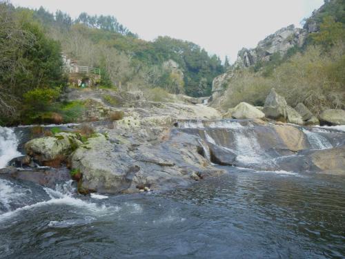 a river with rocks and waterfalls at Altamira in Caldas de Reis