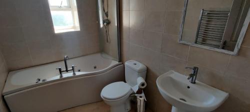 La salle de bains est pourvue d'une baignoire, de toilettes et d'un lavabo. dans l'établissement Golden Plover at Plover Cottage Lindley, à Huddersfield