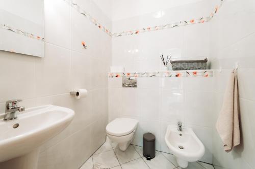 a white bathroom with a toilet and a sink at Holiday house Liptovský Ján in Liptovský Ján