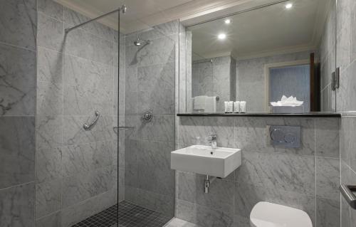 a bathroom with a sink and a shower with a mirror at Eyre Square Hotel in Galway