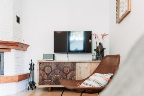 a living room with a chair in front of a tv at Holiday house Liptovský Ján in Liptovský Ján
