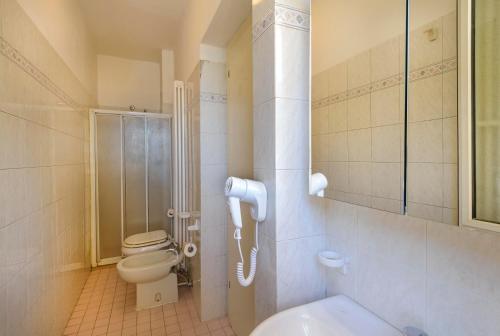 La salle de bains est pourvue d'une douche et de toilettes. dans l'établissement Residence Royal, à Rimini