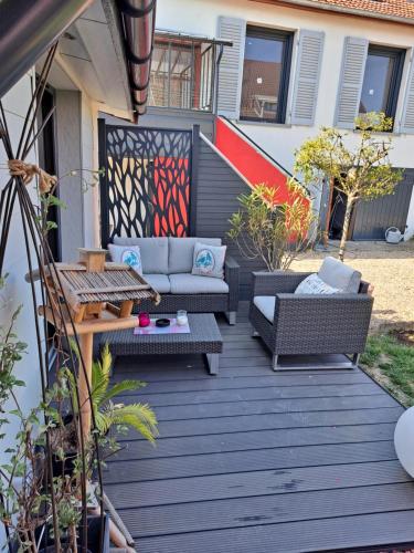 a patio with a couch and chairs on a deck at Grain de folie in Beaune