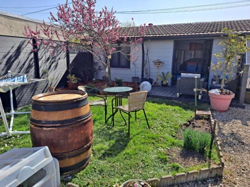a yard with a table and a barrel at Grain de folie in Beaune
