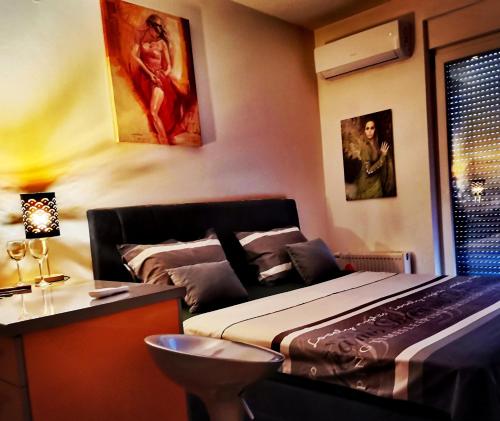 1 dormitorio con cama, escritorio y ventana en Apartment CITY en Doboj
