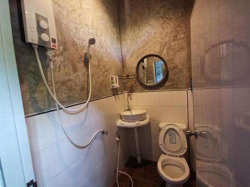 a bathroom with a toilet and a sink and a mirror at Baan Rock Inn in Ko Tao