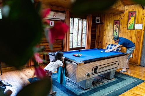 a man and a little girl playing pool in a room at Mtunzini Forest Lodge Self Catering Resort in Mtunzini