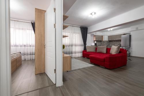 a living room with a red couch and a television at Luxury Ultracentral in Piteşti