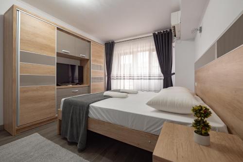 a small bedroom with a bed and a television at Luxury Ultracentral in Piteşti