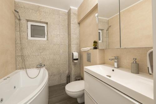 a bathroom with a toilet and a sink and a tub at Luxury Ultracentral in Piteşti