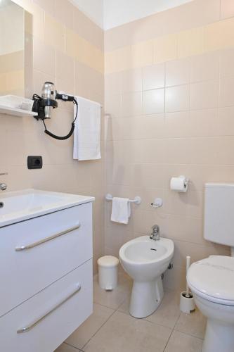 a white bathroom with a toilet and a sink at Hotel Marco's in Como