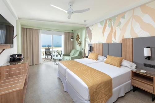 a hotel room with a bed and a television at Hotel Riu Palace Maspalomas - Adults Only in Maspalomas