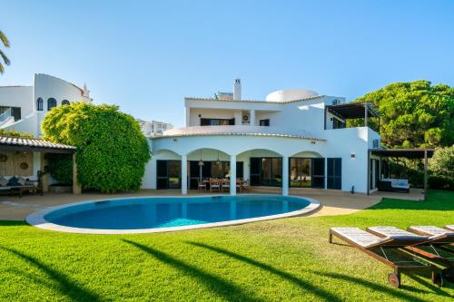a villa with a swimming pool in front of a house at Luxury Private Family Villa with Pool AC & Parking in Portimão