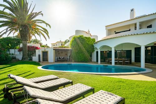 a villa with a swimming pool and two lounge chairs at Luxury Private Family Villa with Pool AC & Parking in Portimão