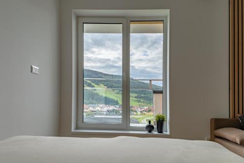 a bedroom with a large window with a view at Zuberka Vila Zuberec in Zuberec