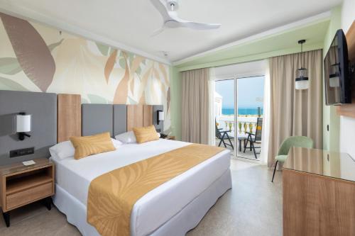 a bedroom with a bed and a view of the ocean at Hotel Riu Palace Maspalomas - Adults Only in Maspalomas