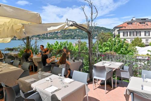 a restaurant with tables and chairs and a view of the water at Hotel Marco's in Como