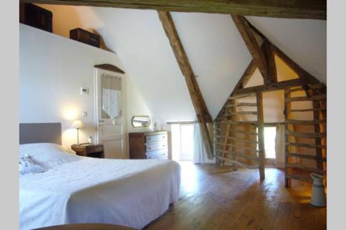 een slaapkamer met een wit bed en een houten vloer bij Gîte écologique en vallée de la Dordogne Lotoise in Gignac