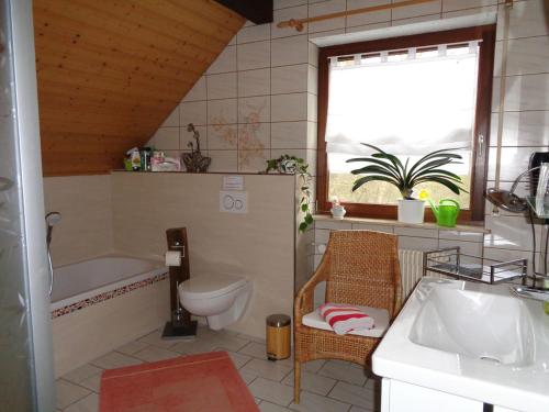een badkamer met een bad, een toilet en een wastafel bij Ferienwohnung Löber in Eußenheim