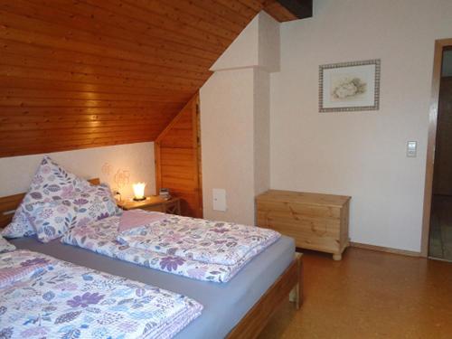 een slaapkamer met 2 bedden en een houten plafond bij Ferienwohnung Löber in Eußenheim