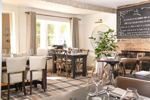 um restaurante com mesas e cadeiras e um quadro-negro em The Woodman Inn em Huddersfield