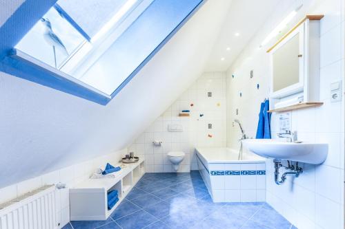 een badkamer met een wastafel, een toilet en een dakraam bij Sonnensteg 5 - Ein Tag am Meer in Ostseebad Sellin