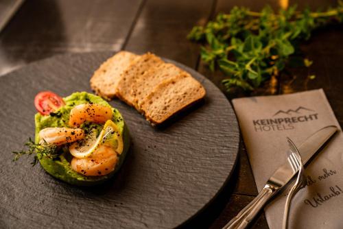 a plate of food with shrimp and bread on a table at Almwelt Austria in Schladming