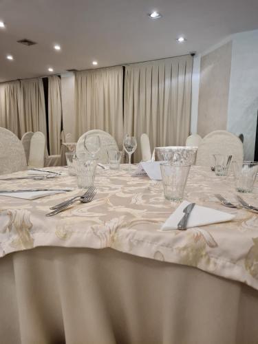 a long table with glasses and silverware on it at Accord Le Rose in Palagiano