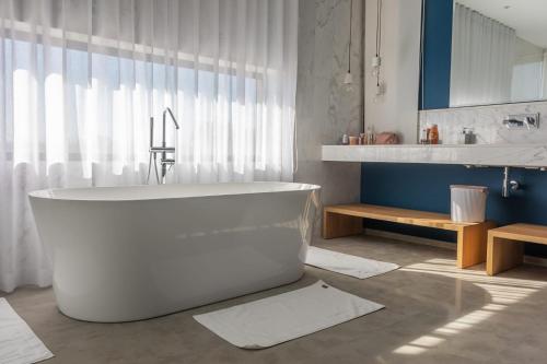 a white bathroom with a tub and a sink at Villa familiale aux portes de Marrakech in Marrakesh