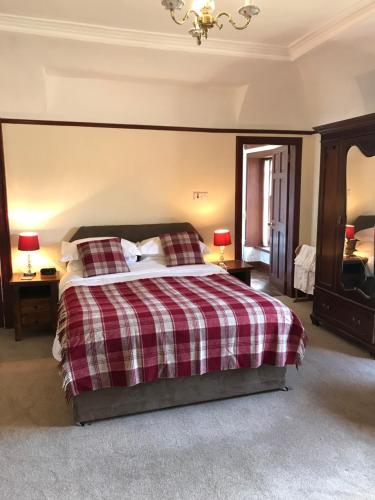 a bedroom with a bed with a checkered blanket at Cavell House in Inverness