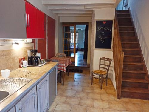 eine Küche mit einer Theke, einem Tisch und einer Treppe in der Unterkunft DUPLEX "Au Village" 89120 Dicy in Dicy