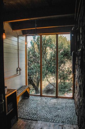 an empty room with a large window and a bench at Stonewood Mountain Cabin in Breërivier