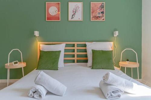 1 dormitorio con 1 cama blanca grande y paredes verdes en matcha cerisier - matcha home Serémange, en Serémange-Erzange