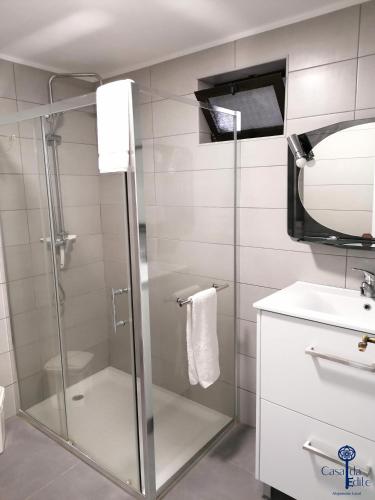 a glass shower in a bathroom with a sink at Casa da Edite in Ponta do Sol