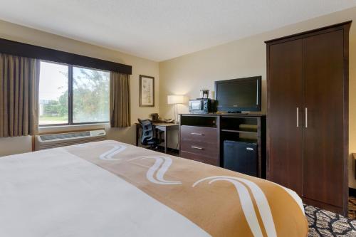 a hotel room with a bed and a flat screen tv at Quality Inn in Oshkosh