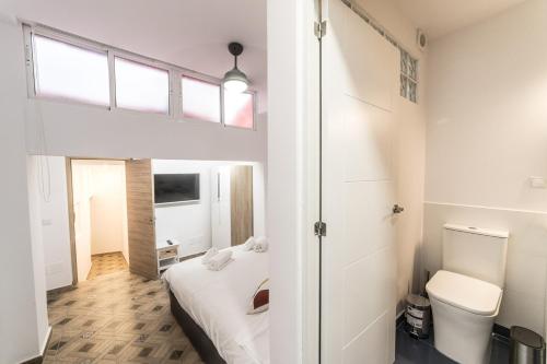 a small bedroom with a bed and a toilet at Moonkey - Casa Toledo in Alicante