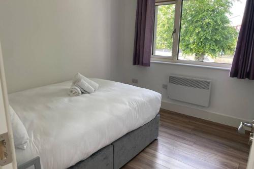 a white bedroom with a bed and a window at Apt 3 Silver Spruce - Killarney Town Free Parking in Killarney